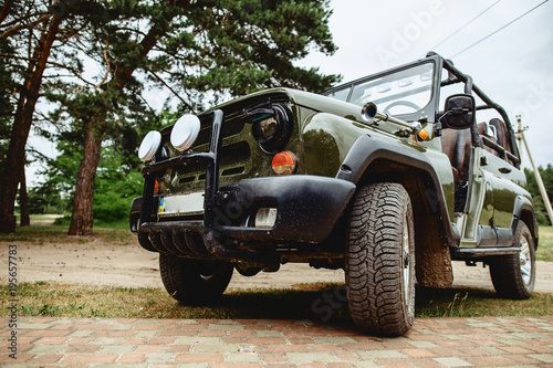 a jeep with a dark green color with aggressive rubber photo