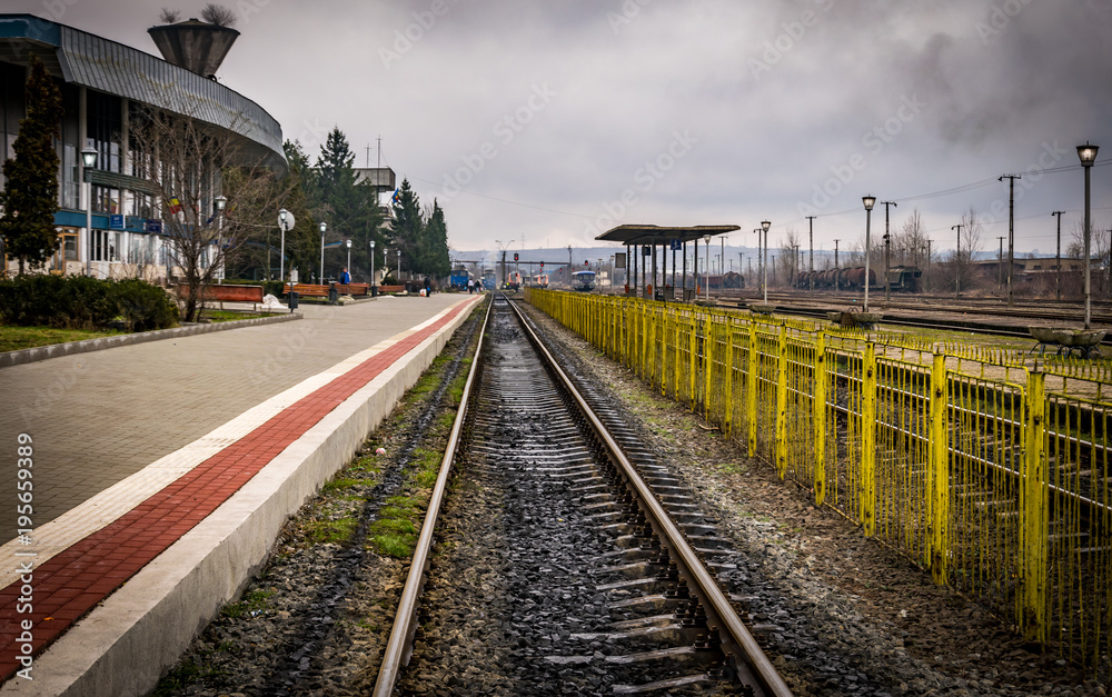 Fototapeta premium This is a train station with a yellow fence 