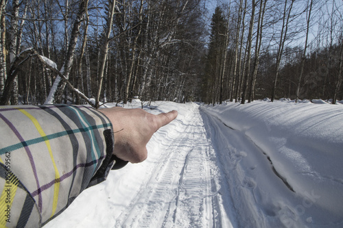 winter. snow. road. the finger of the hand shows the direction of movement. photo