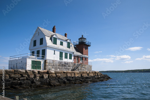 Old Brick and Wooden Lighthouse Sits at End of Breakwater in Maine