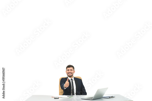 The happy businessman at the desktop thumbs up on the white background © realstock1