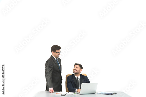 The two businessmen work at the desktop on the white background