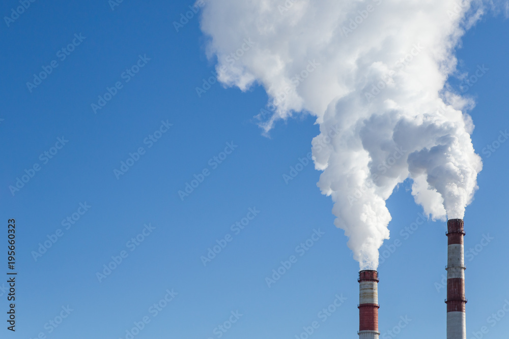 Air pollution. Factory pipes with smoke in the blue sky. Ecology problem