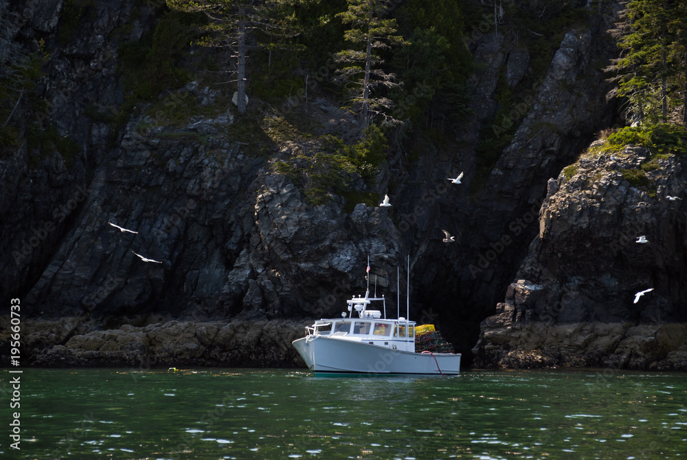 Lobster Boat Fishing by Rocky Island Cliffs in Maine