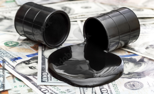 Φωτογραφία Whole barrel of oil and crude oil spilled from barrel on the dollar bills
