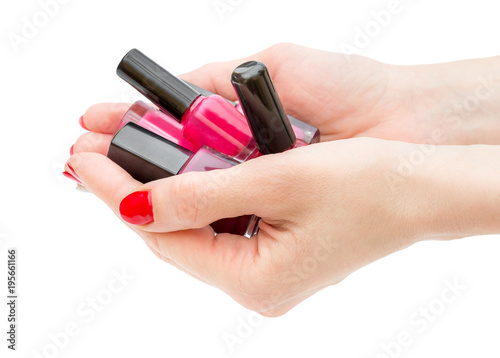  Female s hands holding bottles with nail polish. Isolated on white.