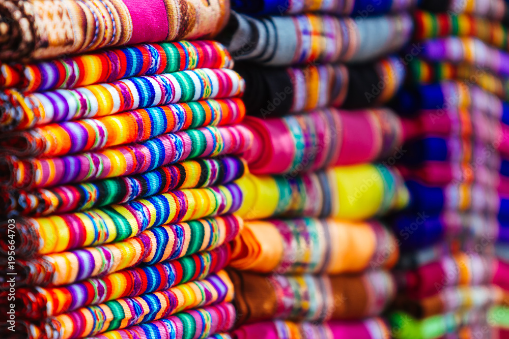 Macro close-up of colorful blankets stacked with Andean designs