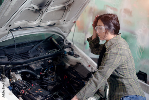 Woman in garage is repairing car