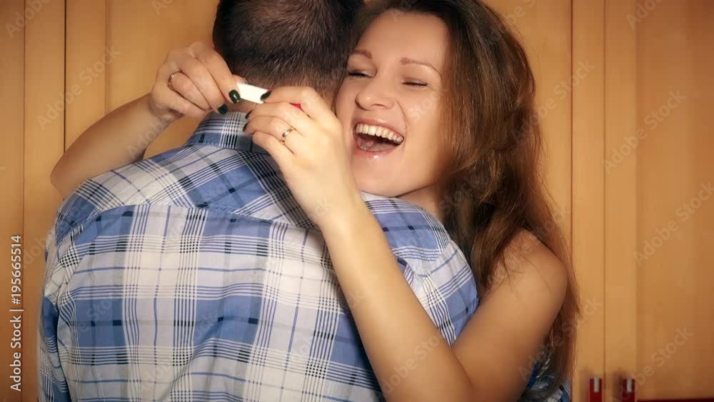 Happy smiling girl with pregnancy test in hands embracing with her man boy Happy smiling girl with pregnancy test in hands embracing with her man boy