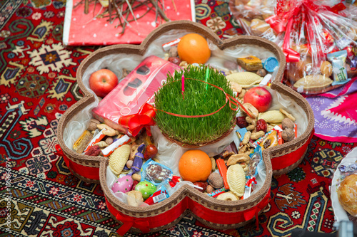 Novruz tray plate with Azerbaijan national pastry pakhlava and shekerbura purple silk scarf . Novruz copper tray plate with Azerbaijan national pastry pakhlava and shekerbura and green semeni © Adil