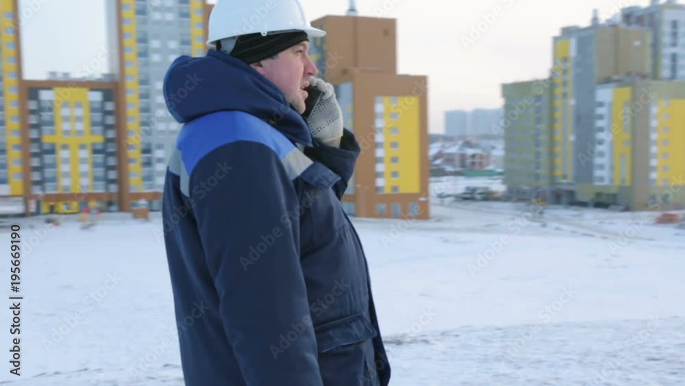 Builder engineer at construction site talking on phone Builder engineer at construction site talking on phone