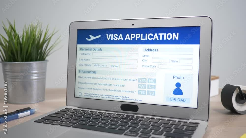 Visa application showing on a laptop computer screen sitting on a desk. Camera is slowly turning around the computer.