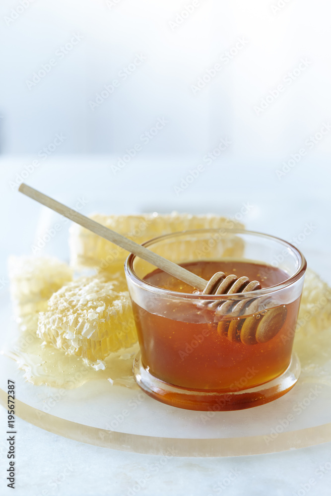 Glass bowl with honey and honey dipper and honey combs Glass bowl with honey and honey dipper and honey combs