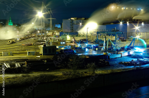 Steel hut in Völklingen in the Saarland in Germany at night in the foreground the Autonahn a620 and the river Saar, the photo shows the production of steel from scrap loaded in railway wagons