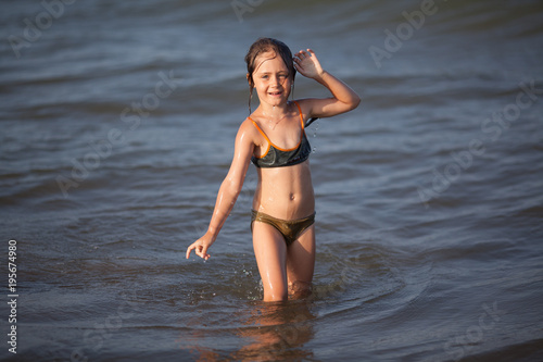 Little girl in bikini plays in the sea Stock Photo | Adobe Stock