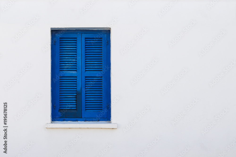 Blue window shutter on white stone house Blue window shutter on white stone house