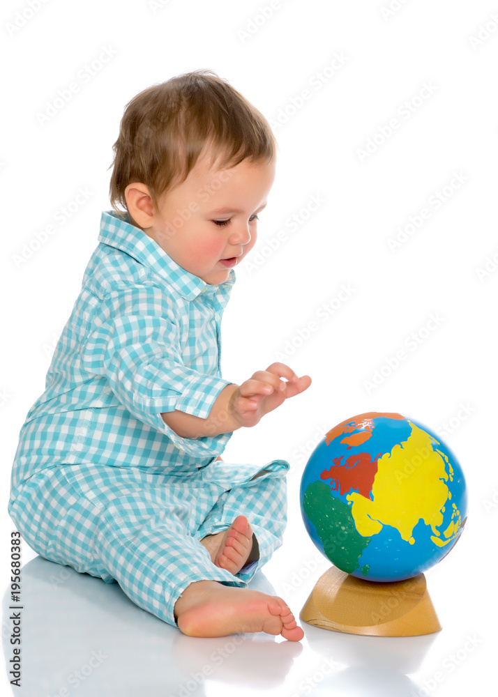 A little boy is playing with a globe. A little boy is playing with a globe.