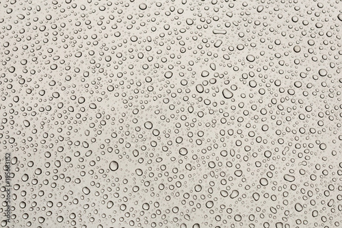 Texture of water drops on grey metal background. Small various drops with shadows on gray metalic paint. Flat view. Clear abstract water background with copyspace