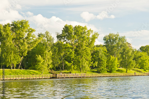 wooden path along the lake on summer day