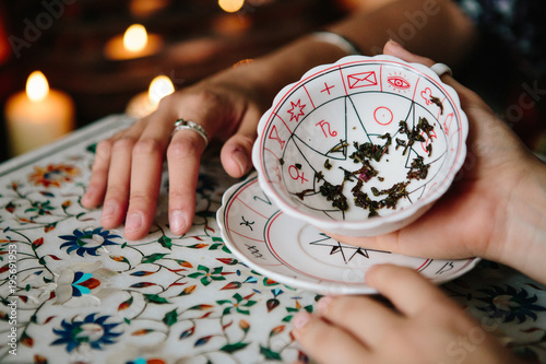 Woman fortune teller reading tea leaves photo