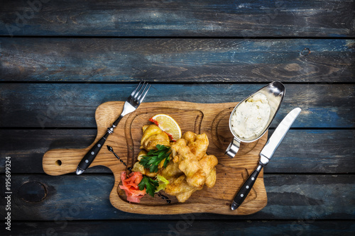 Fish and Chips with sauce tartar served with cutlery photo