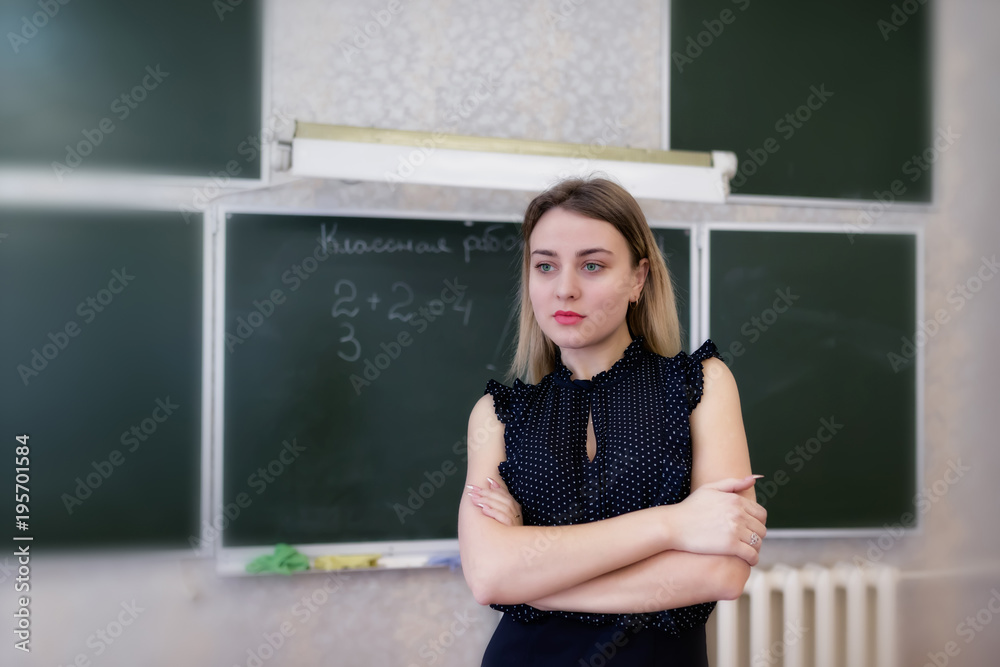 Strict young teacher blonde standing resting her hands on her hips Strict young teacher blonde standing resting her hands on her hips