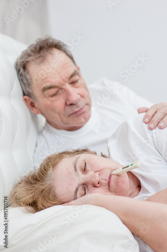 an elderly man takes care of an senior woman