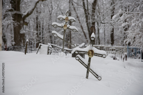Two crosses in the snow in the cemetery