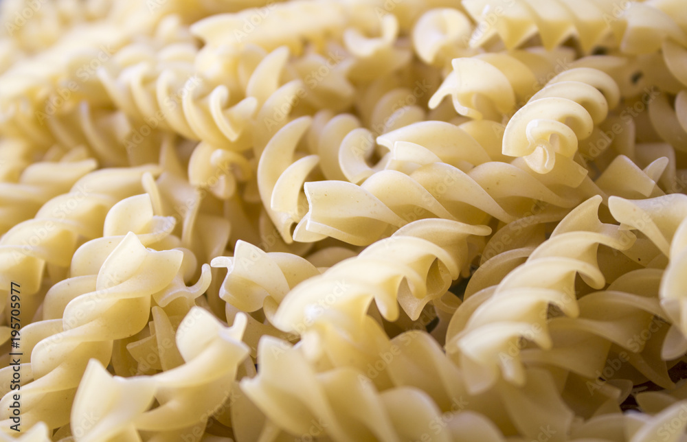 Dry pasta background, healthy food, yellow background Dry pasta background, healthy food, yellow background