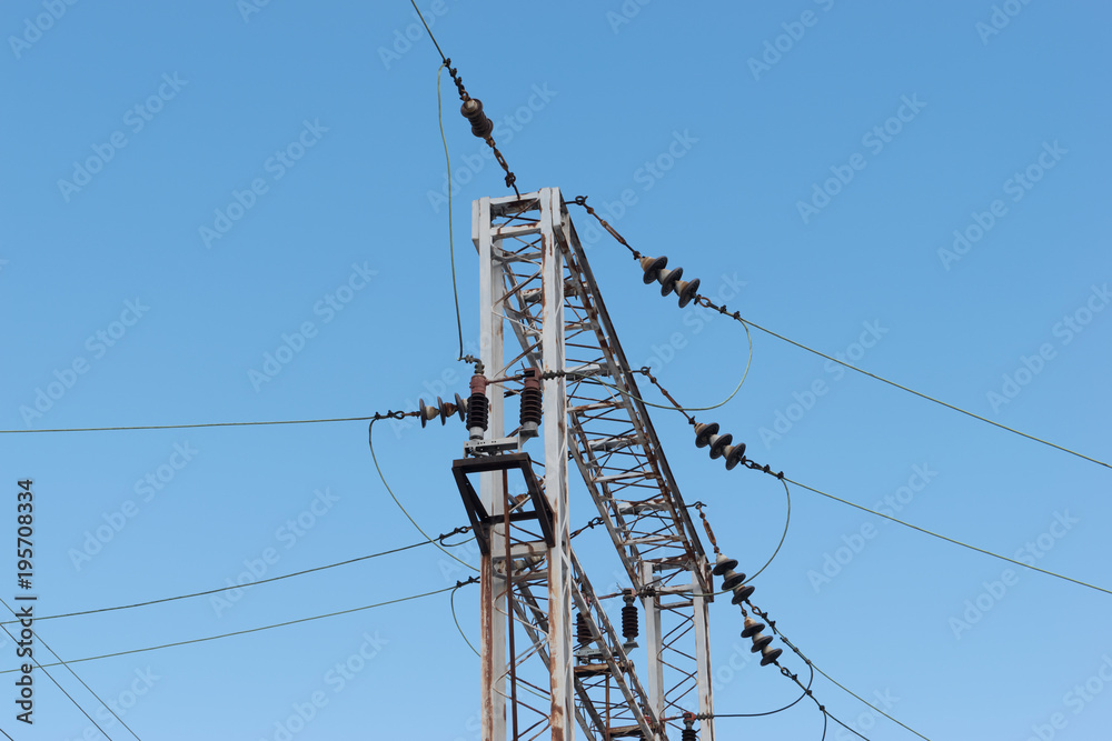 Train or railway power line support. Railway power lines with high voltage electricity on metal poles against blue sky. Train or railway power line support. Railway power lines with high voltage electricity on metal poles against blue sky.