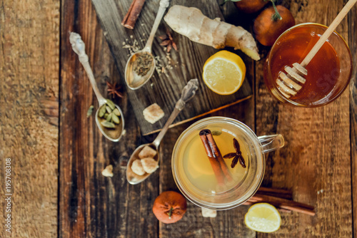 Vitamin tea with lemon and honey, ginger and spices on wooden background . The concept of spring beriberi and colds.