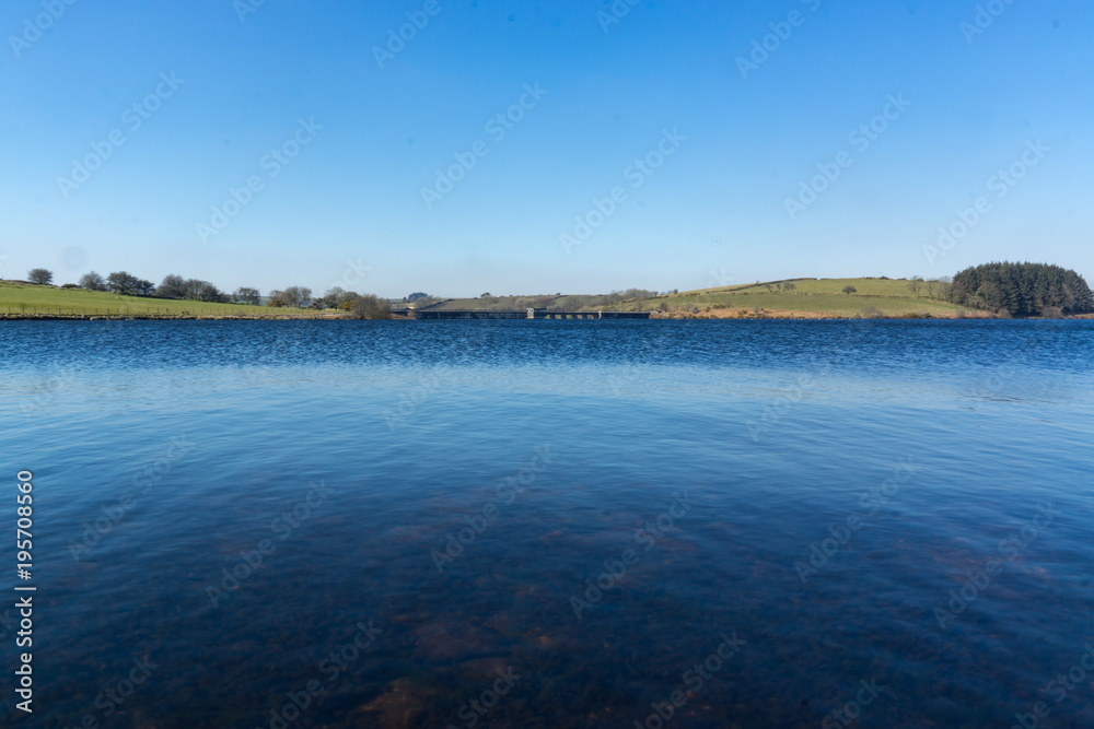 A landscape view of Siblyback Lake in Cornwall, UK on a clear day.