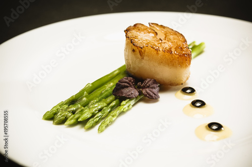 scallop with green asparagus on white plate