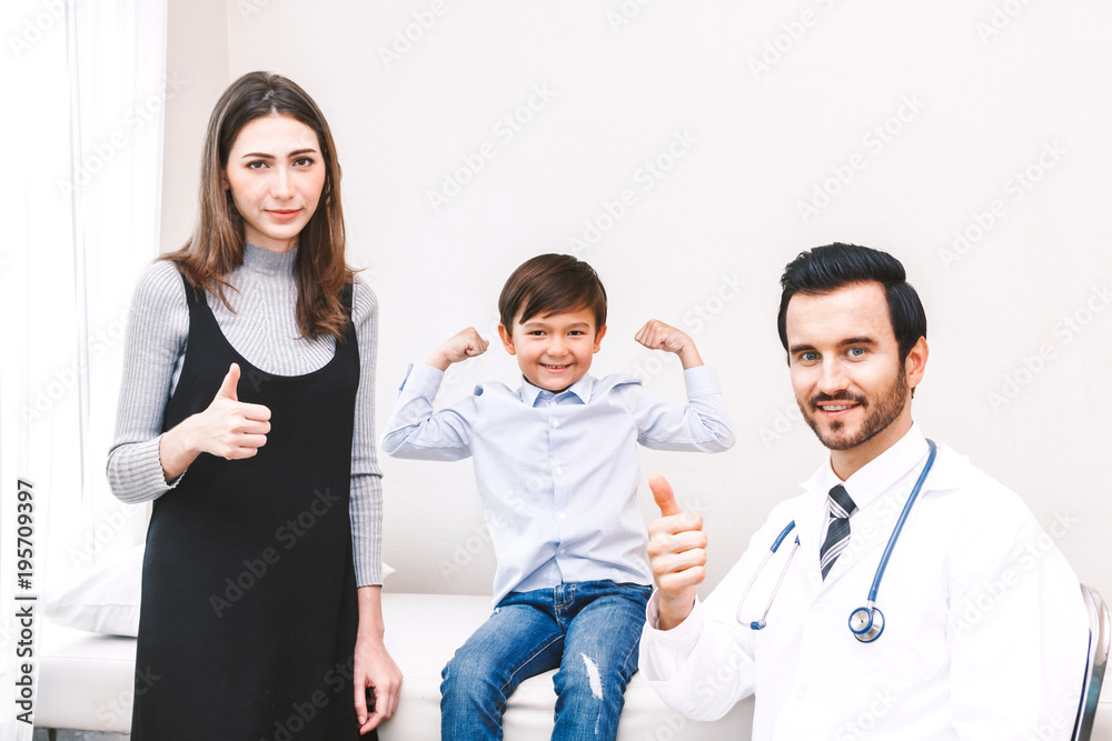 Doctor with cute little boy and mom showing thump up OK signs in hospital Doctor with cute little boy and mom showing thump up OK signs in hospital