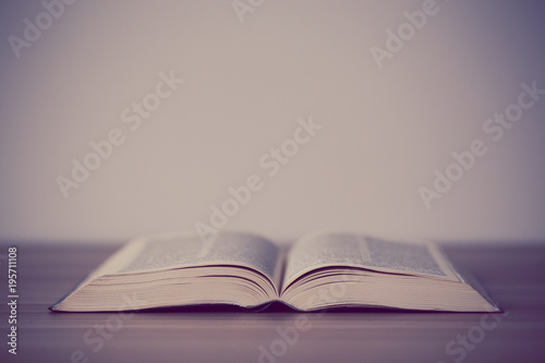 An opened holy bible on a wooden table