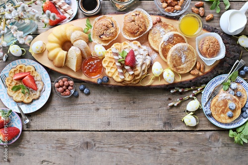 Easter dessert table. Pancakes,waffles and bundt cake with fresh berries and various of topping. Overhead view, copy space