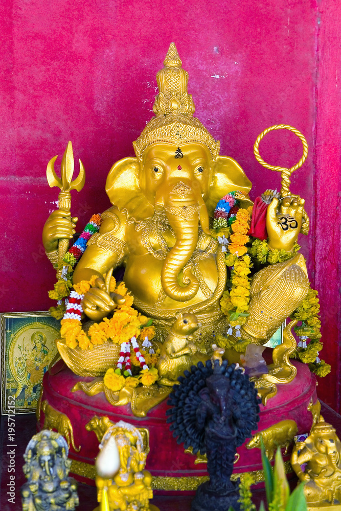 Obraz premium Gold sculpture of God Ganesha with the head of an elephant.
