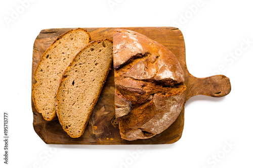 Loaf of rustic german bread on wooden board, isolated on white