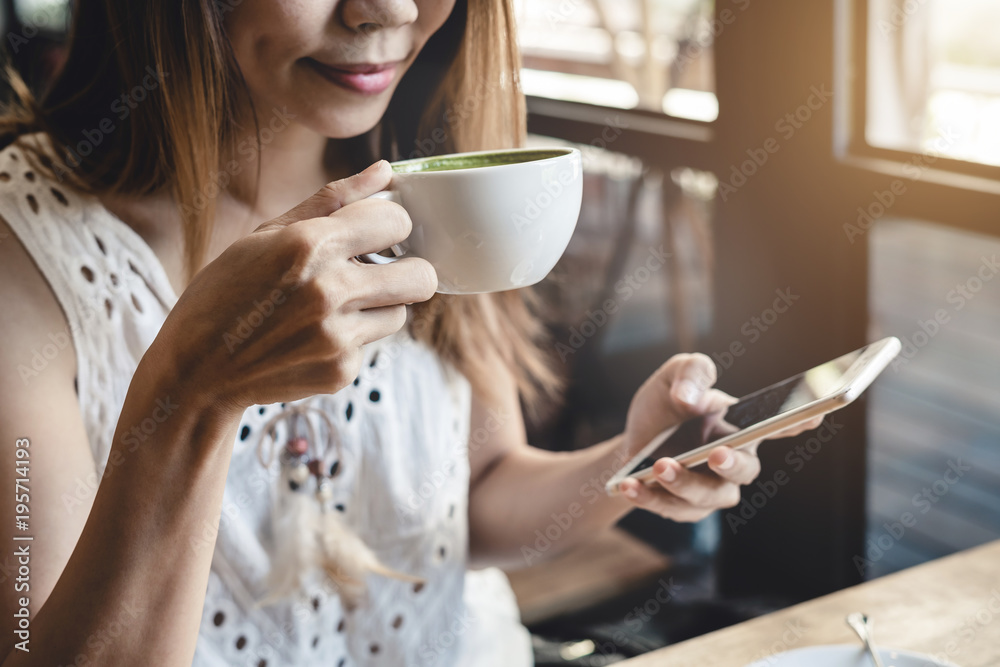 Young woman using smart phone and drinking coffee in cafe Young woman using smart phone and drinking coffee in cafe