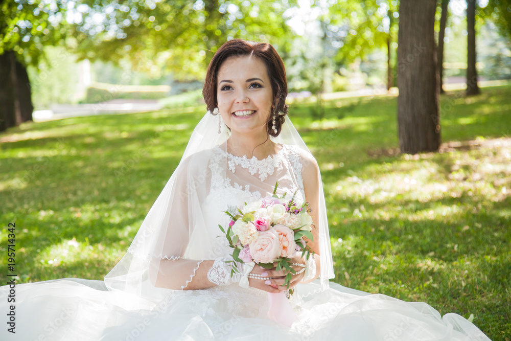 Beautiful newlyweds. Summer wedding. Bride with a bouquet of pink roses