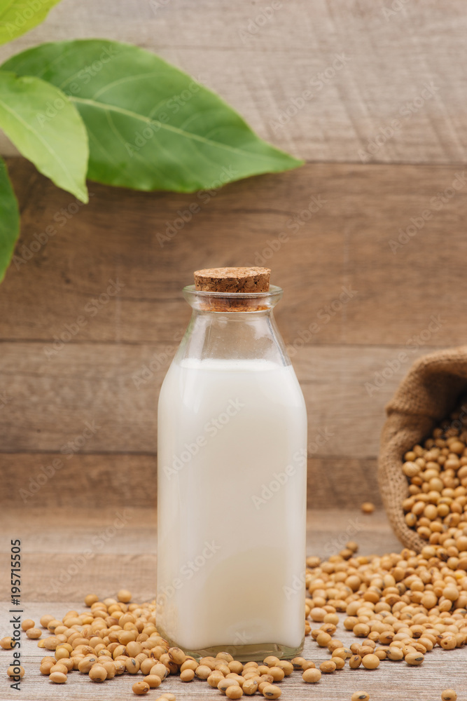 Bottle of soy milk and soybean on wooden table Bottle of soy milk and soybean on wooden table