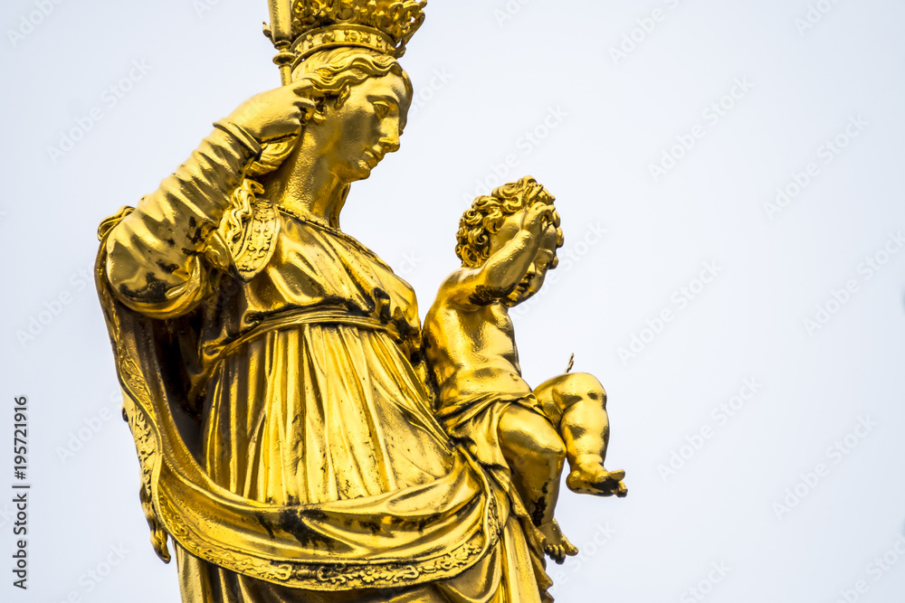 Fototapeta premium Golden statue of the Virgin Mary in the city center of Munich, Germany