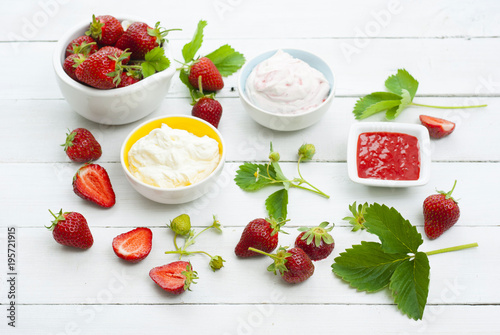 strawberry fruits with jam and whipped cream dessert on white wood table background