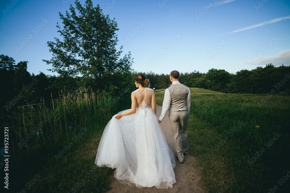 stylish bride and groom walking in the Park