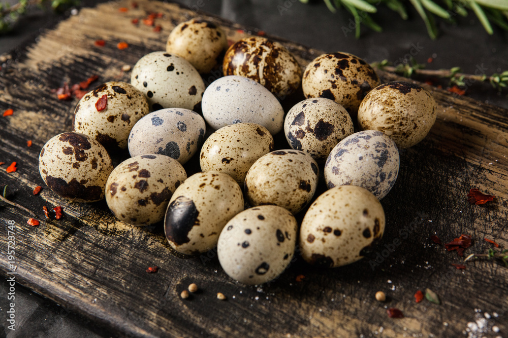Quails eggs on old wooden cutting board. Close up. Quails eggs on old wooden cutting board. Close up.