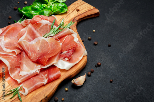 Italian prosciutto crudo or spanish jamon. Raw ham on wooden cutting board photo