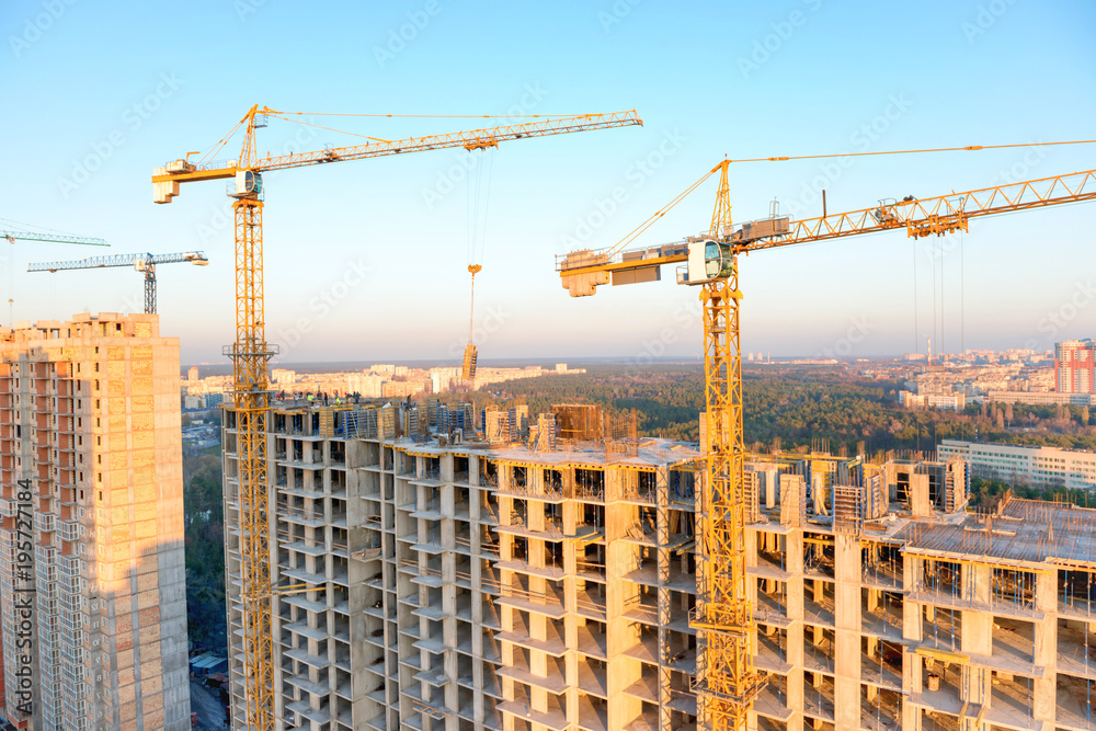 Construction with cranes and workers on industrial building site