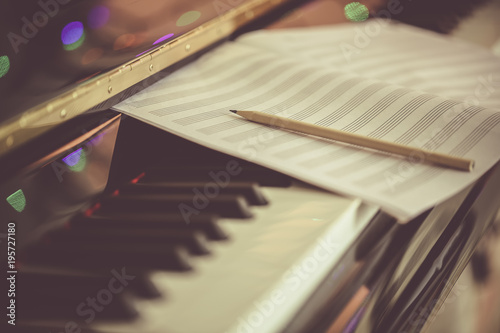 Compose Concept. Pencil and sheet music on the piano keyboard
