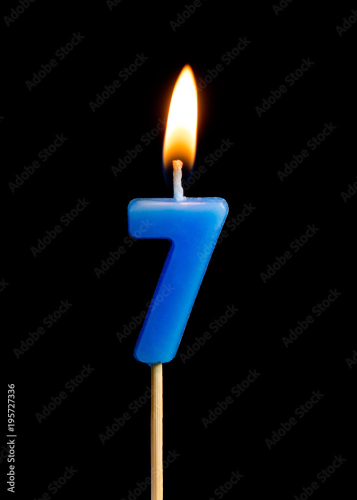 Burning candle in the form of seven figures (numbers, dates) for cake isolated on black background. The concept of celebrating a birthday, anniversary, important date, holiday, table setting Burning candle in the form of seven figures (numbers, dates) for cake isolated on black background. The concept of celebrating a birthday, anniversary, important date, holiday, table setting
