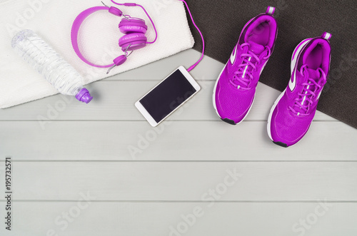 Sport and fitness accessories, healthy and active lifestyle concept on wooden floor background with copy space. Products with vibrant, punchy pastel colours. Image taken from above, top view.